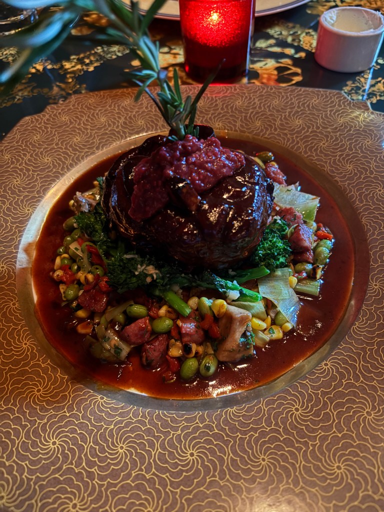 Roast pork on a bed of beans in cranberry sauce.