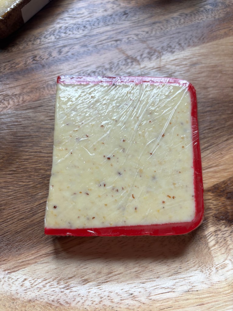A wedge of "Red Dragon Cheddar" cheese.